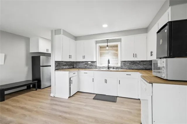 a kitchen with granite countertop a stove a sink and a refrigerator