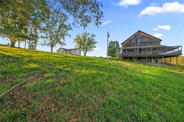 a view of a house with a big yard and large tree