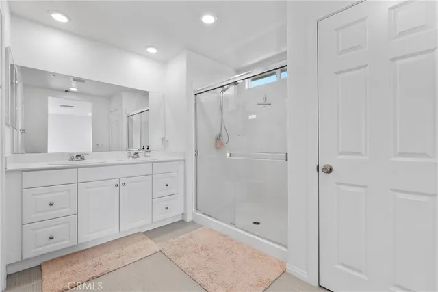 a spacious bathroom with a shower sink double and mirror