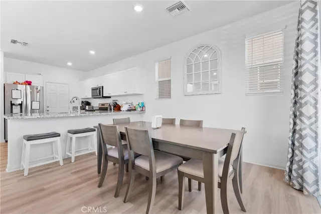 a kitchen with kitchen island a dining table and chairs