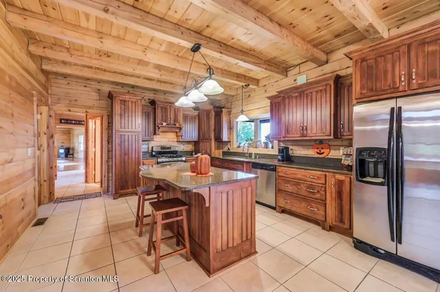 a room with stainless steel appliances kitchen island granite countertop a stove and a cabinets