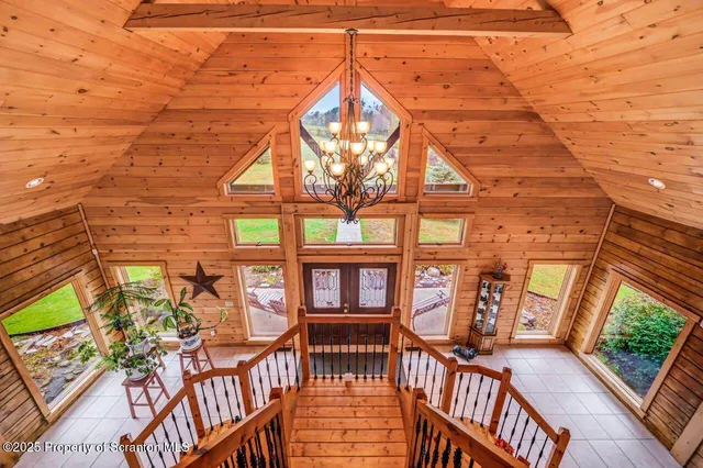 a living room with furniture a flat screen tv and floor to ceiling window