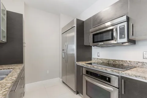 a kitchen with granite countertop a stove and a microwave