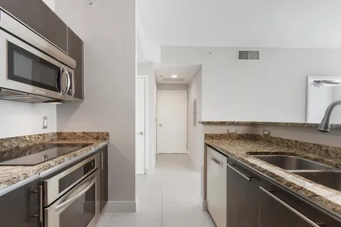 a kitchen with granite countertop a stove and a sink