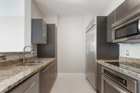 a kitchen with stainless steel appliances granite countertop a sink and a stove top oven