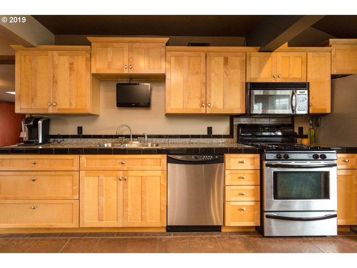 91978 Lewis And Clark Road Astoria, OR 97103 - Photo 19 of 32 a kitchen with stainless steel appliances granite countertop a stove a sink and a microwave