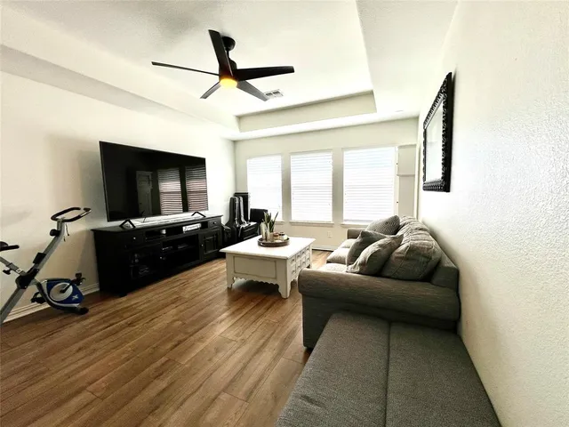 a living room with furniture flat screen tv and a window