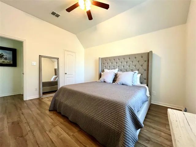 a bedroom with a large bed and a chandelier
