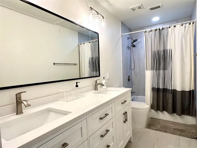 a bathroom with a double vanity sink and a mirror