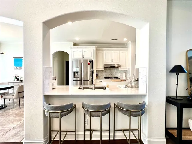 a kitchen with a sink and chairs
