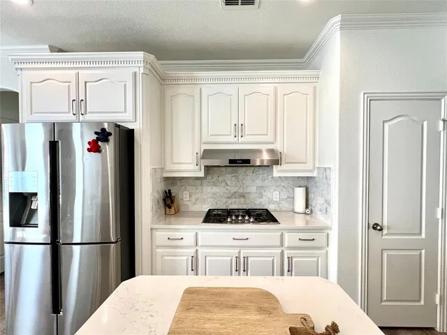 a kitchen with stainless steel appliances a refrigerator sink and cabinets