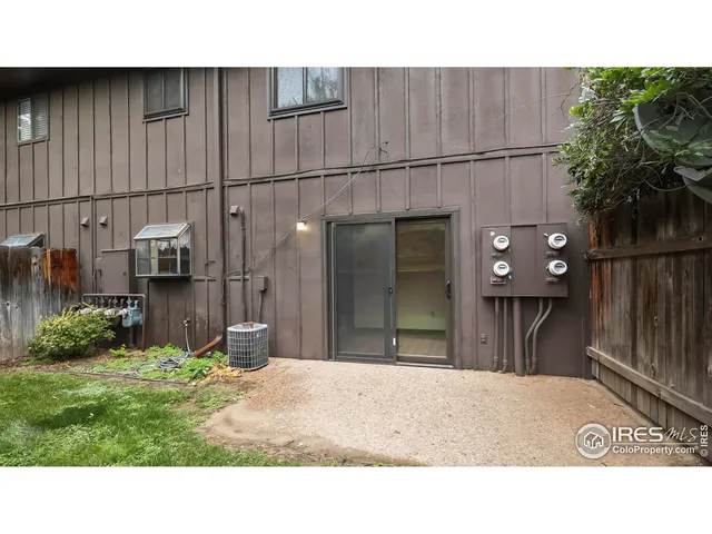 a black and white house with a yard and wooden fence