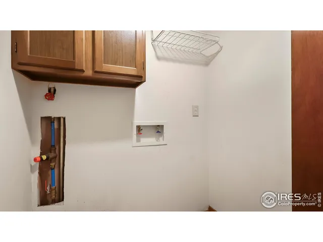 a open area with a refrigerator and cabinets