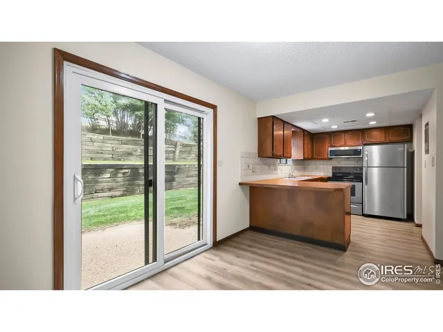 a kitchen with stainless steel appliances granite countertop a refrigerator a sink a stove and a refrigerator