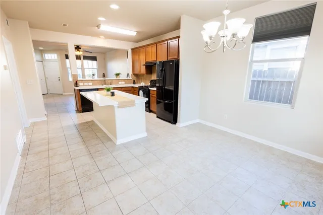 a view of kitchen with granite countertop cabinets and refrigerator