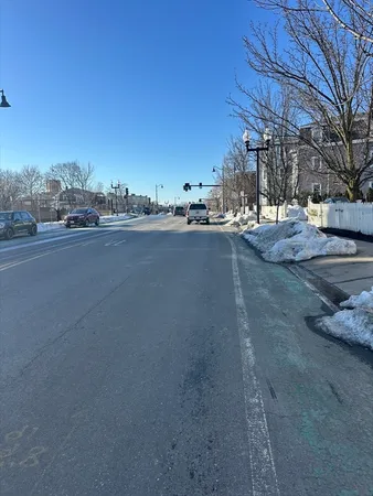 a view of large building with snow on the road