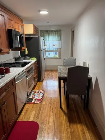 a kitchen with a table chairs refrigerator and microwave