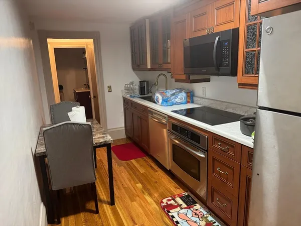 a kitchen with stainless steel appliances granite countertop a sink wooden cabinets and a refrigerator