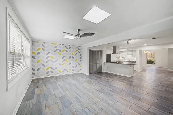 a view of empty room with wooden floor and window