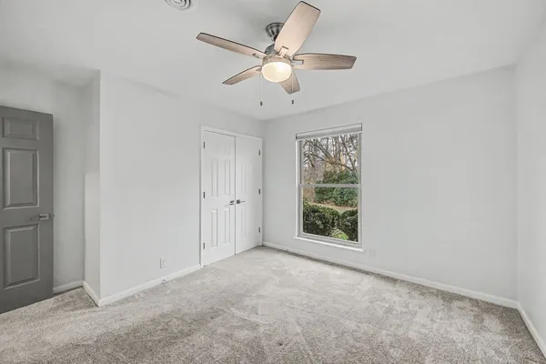 an empty room with fan and windows