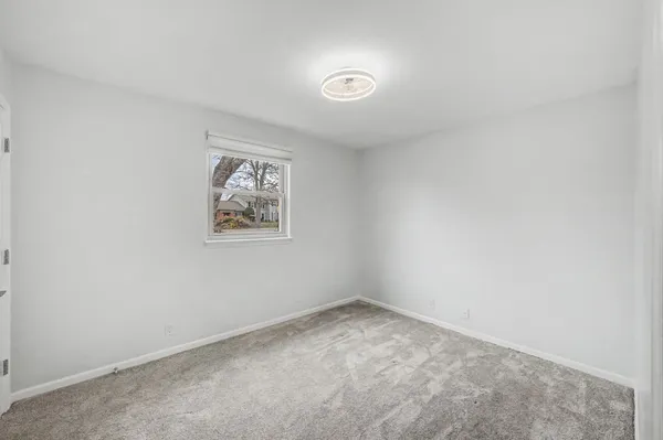 a view of an empty room with a chandelier fan