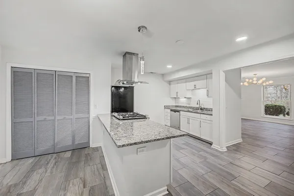 a kitchen with granite countertop a stove a sink and a refrigerator