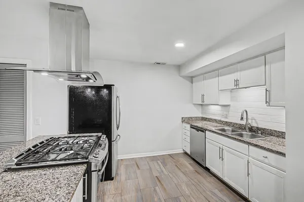 a kitchen with stainless steel appliances granite countertop a sink stove and refrigerator