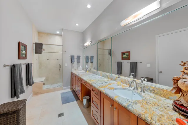 a bathroom with a granite countertop sink a large mirror and a shower