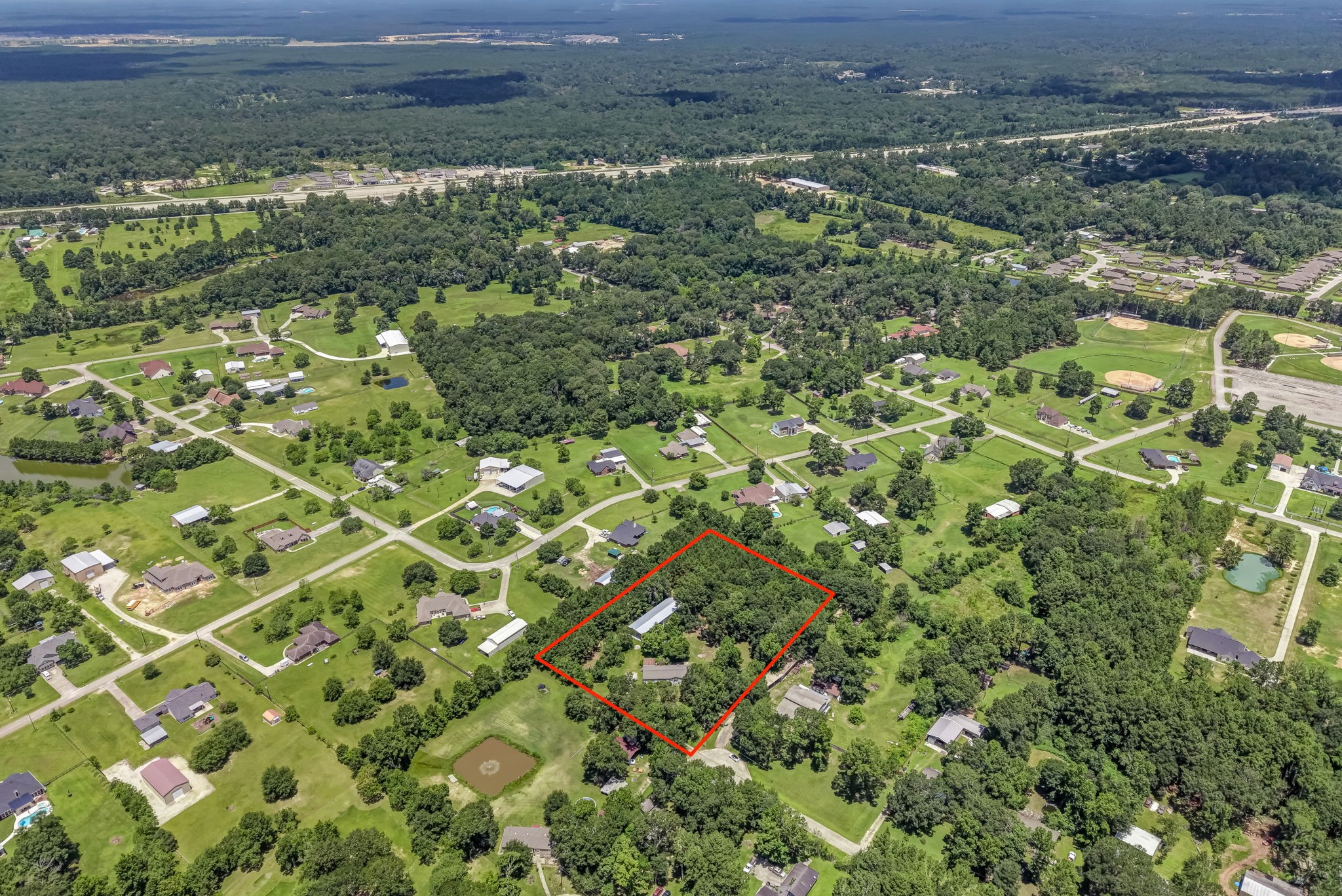 25979 Shade Tree Lane Splendora, TX 77372 - Photo 22 of 22 This aerial view showcases the impressive scale of the nearly 3-acre property, where mature trees, open green space, and existing improvements create the perfect balance of privacy, functionality, and endless potential.