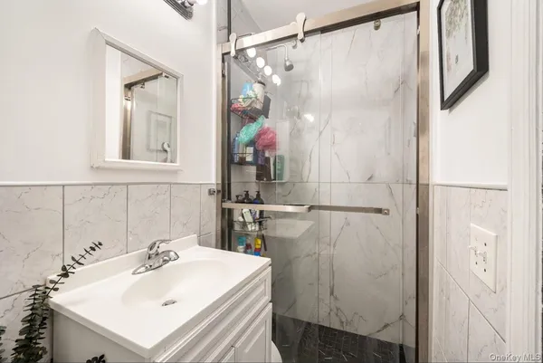 a bathroom with a sink mirror and shower