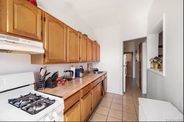 a kitchen with stainless steel appliances a sink a stove a refrigerator and cabinets