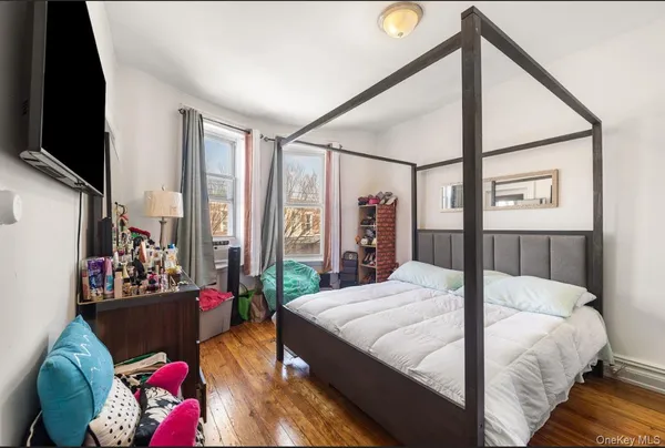 a bedroom with bed and a flat tv screen