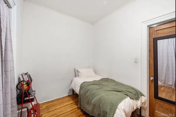 a bedroom with a bed and wooden floor