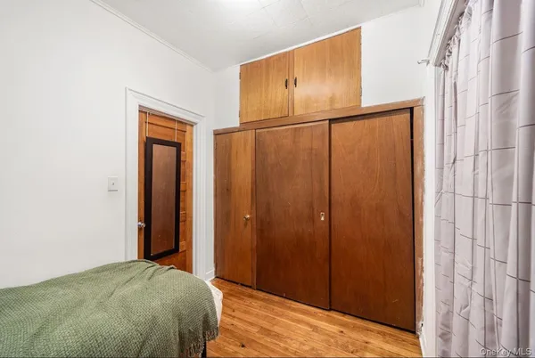 a view of a bedroom with wooden floor