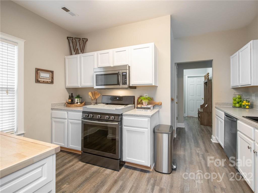 5725 Coopers Ridge Lane Charlotte, NC 28269 - Photo 13 of 39 a kitchen with a stove a sink and a microwave