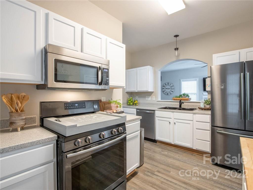5725 Coopers Ridge Lane Charlotte, NC 28269 - Photo 14 of 39 a kitchen with cabinets stainless steel appliances and wooden floor