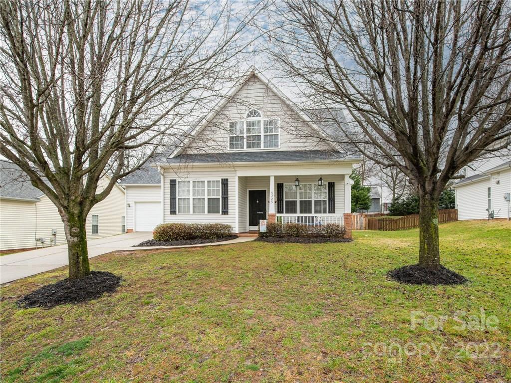 5725 Coopers Ridge Lane Charlotte, NC 28269 - Photo 2 of 39 a front view of a house with a garden and trees