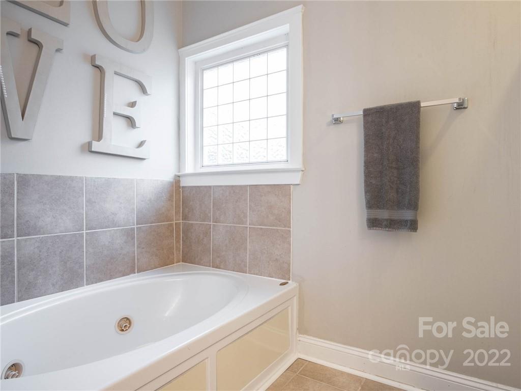 5725 Coopers Ridge Lane Charlotte, NC 28269 - Photo 24 of 39 a bathroom with a tub a window and a shower