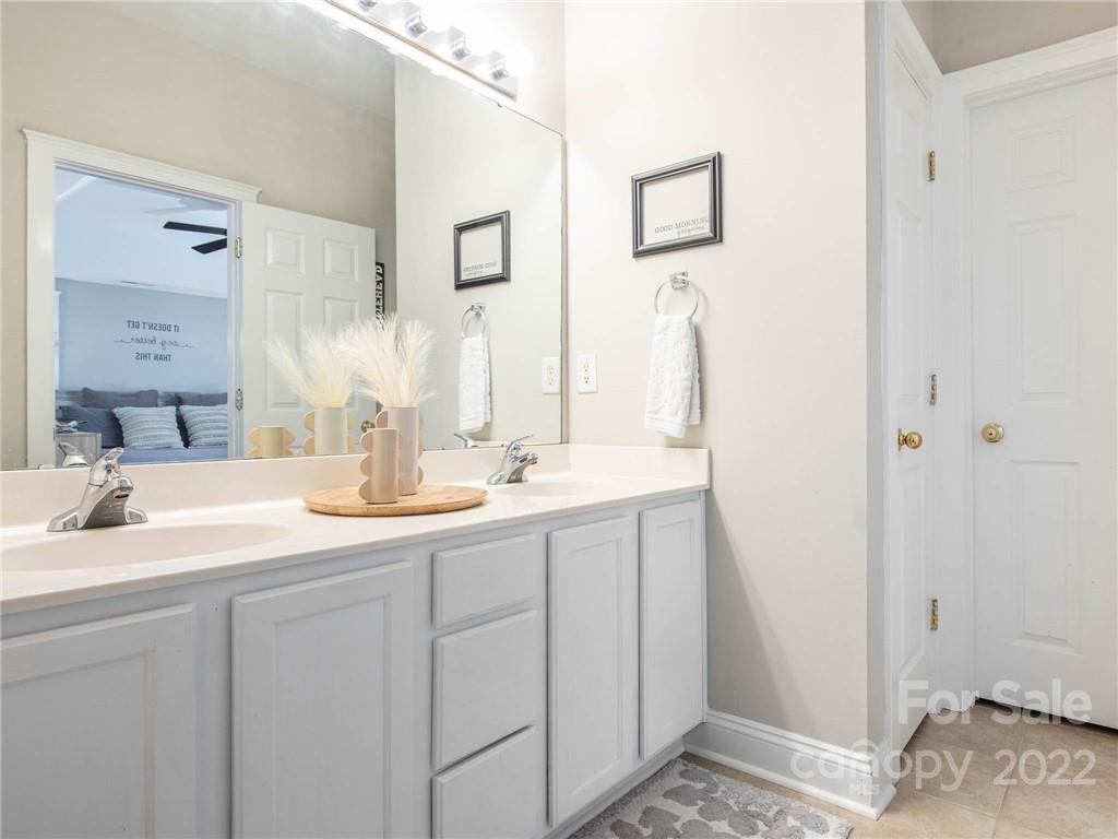 5725 Coopers Ridge Lane Charlotte, NC 28269 - Photo 25 of 39 a bathroom with a sink and a mirror