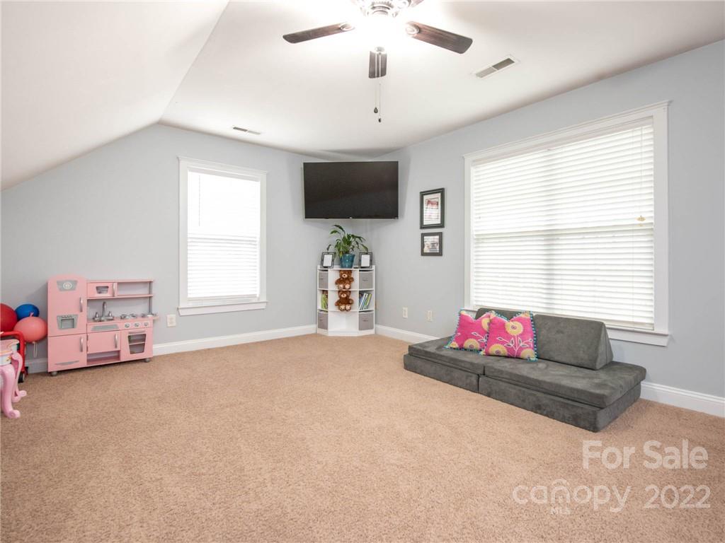 5725 Coopers Ridge Lane Charlotte, NC 28269 - Photo 28 of 39 a living room with hard wood floor windows and a flat screen tv