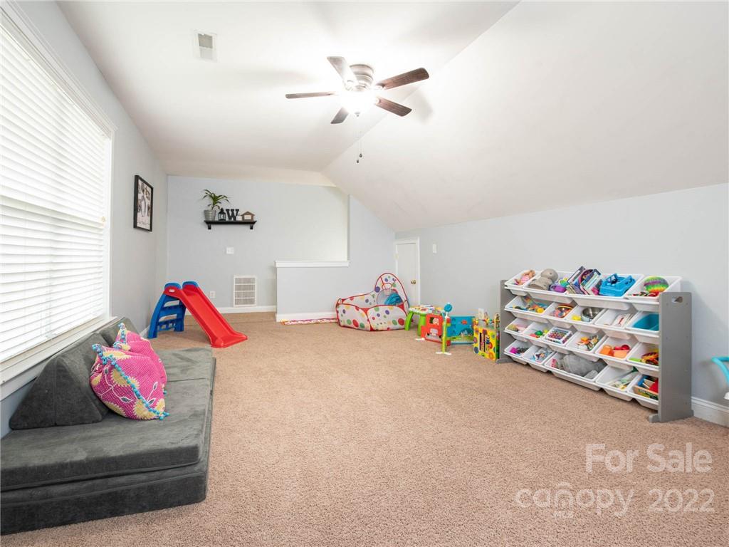 5725 Coopers Ridge Lane Charlotte, NC 28269 - Photo 29 of 39 a bedroom with bed and a couch