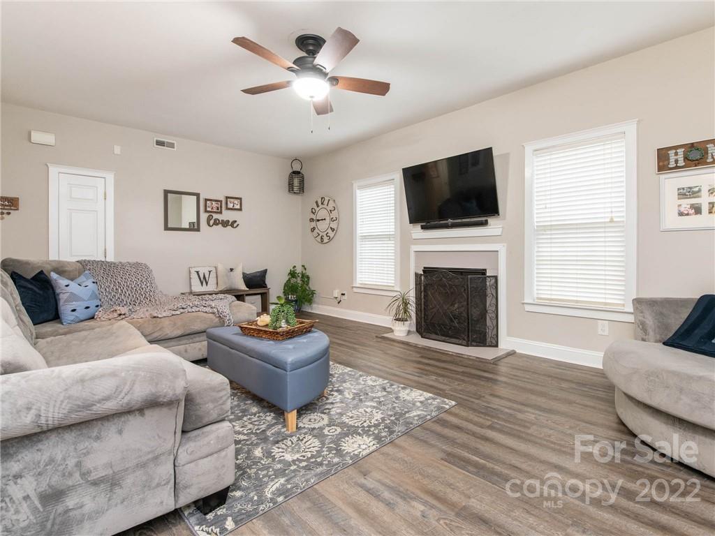 5725 Coopers Ridge Lane Charlotte, NC 28269 - Photo 6 of 39 a living room with furniture a flat screen tv and a fireplace