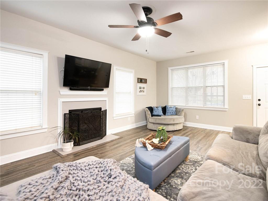 5725 Coopers Ridge Lane Charlotte, NC 28269 - Photo 10 of 39 a living room with furniture a flat screen tv and a fireplace