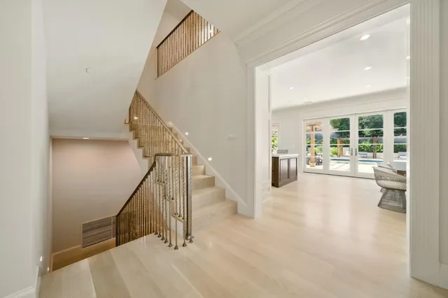 a view of a patio with a table and chairs under an umbrella with a barbeque