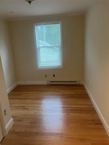 a view of a room with wooden floor and window