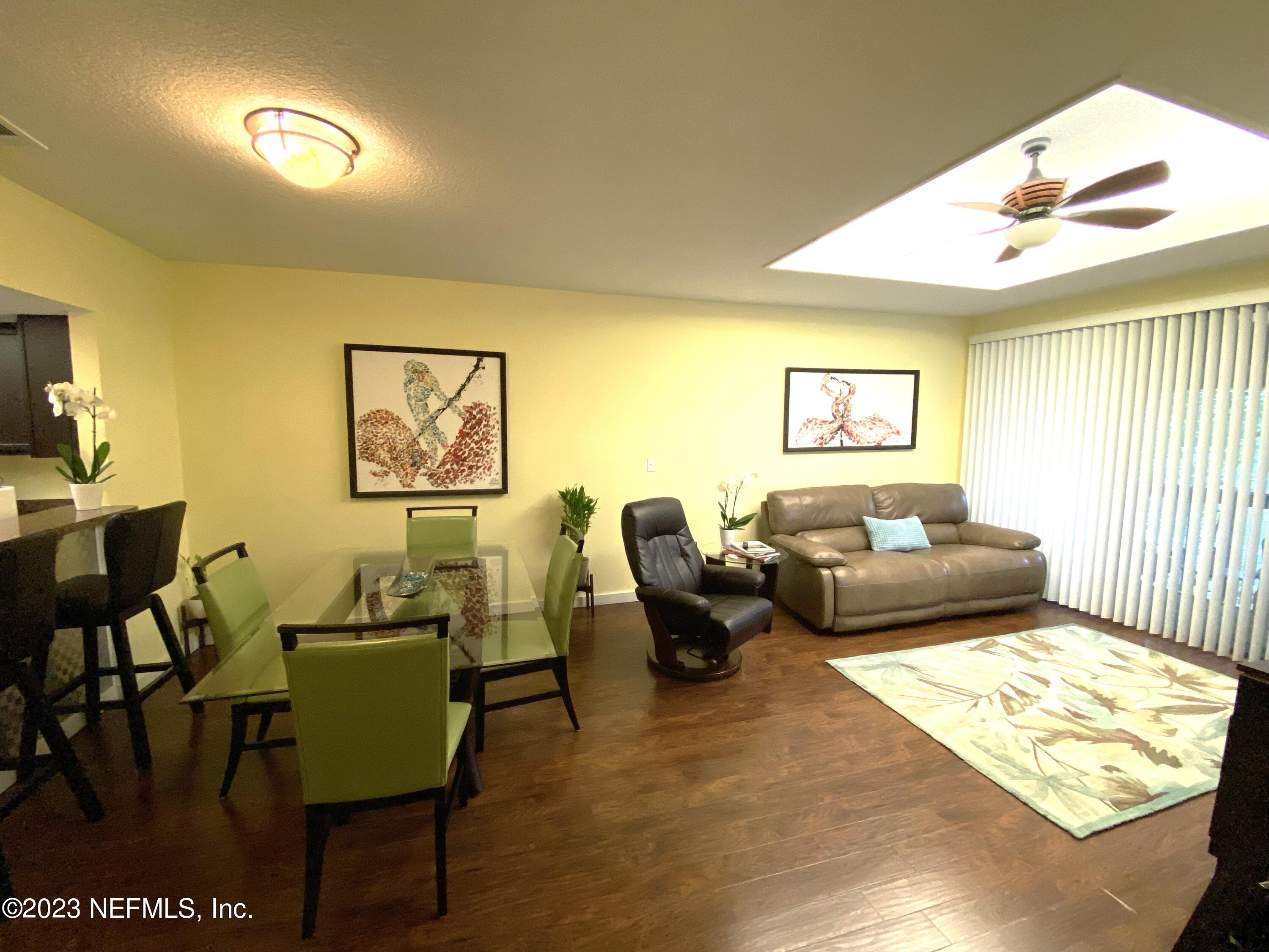 a living room with furniture wooden floor and a window
