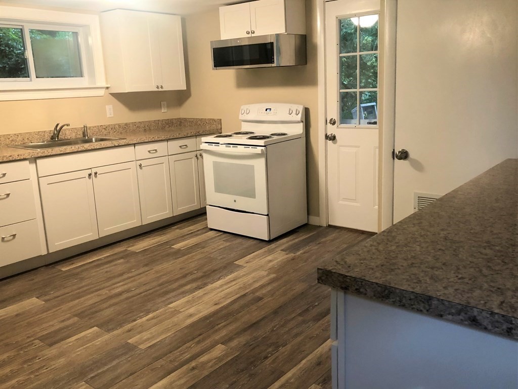 14 Rodgers Circle, Unit REAR North Reading, MA 01864 - Photo 4 of 8 a kitchen with granite countertop a sink and a stove