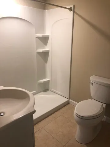a white toilet sitting next to a bath tub