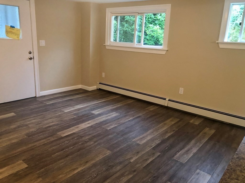 14 Rodgers Circle, Unit REAR North Reading, MA 01864 - Photo 7 of 8 an empty room with wooden floor and windows