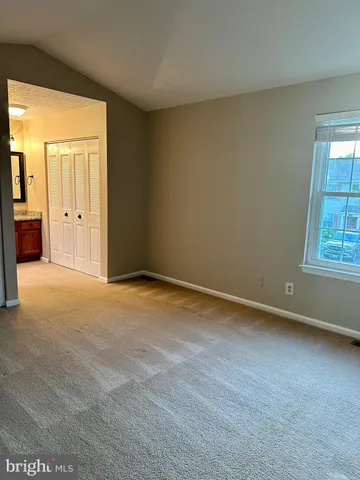 an empty room with windows and closet